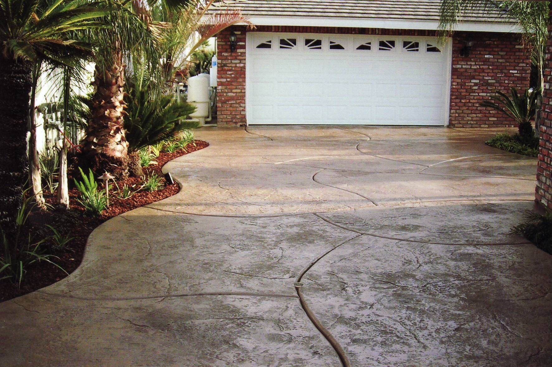 Corona oncrete driveway leading to a white garage door by Superior Concrete