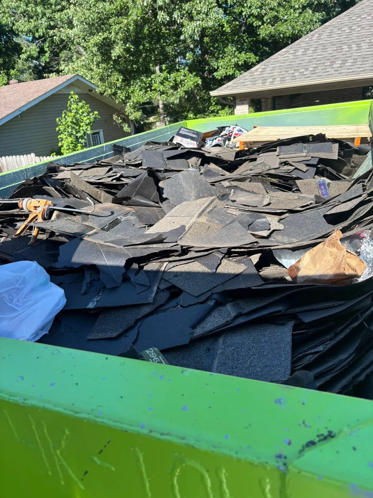 Demolition dumpster loaded with debris on a teardown site in Northeast Arkansas