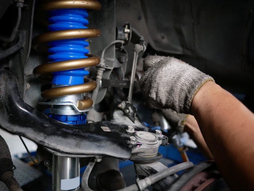 A Person is Working on a Shock Absorber on a Car — Motortorque Automotive in South Grafton, NSW
