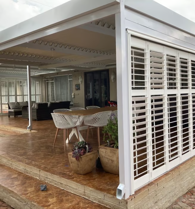 Sophisticated vinyl shutters to extend the living room as installed by Blind & Shutter City Pretoria East.