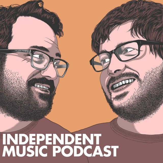 Two men with glasses and beards smile at each other; orange background. 