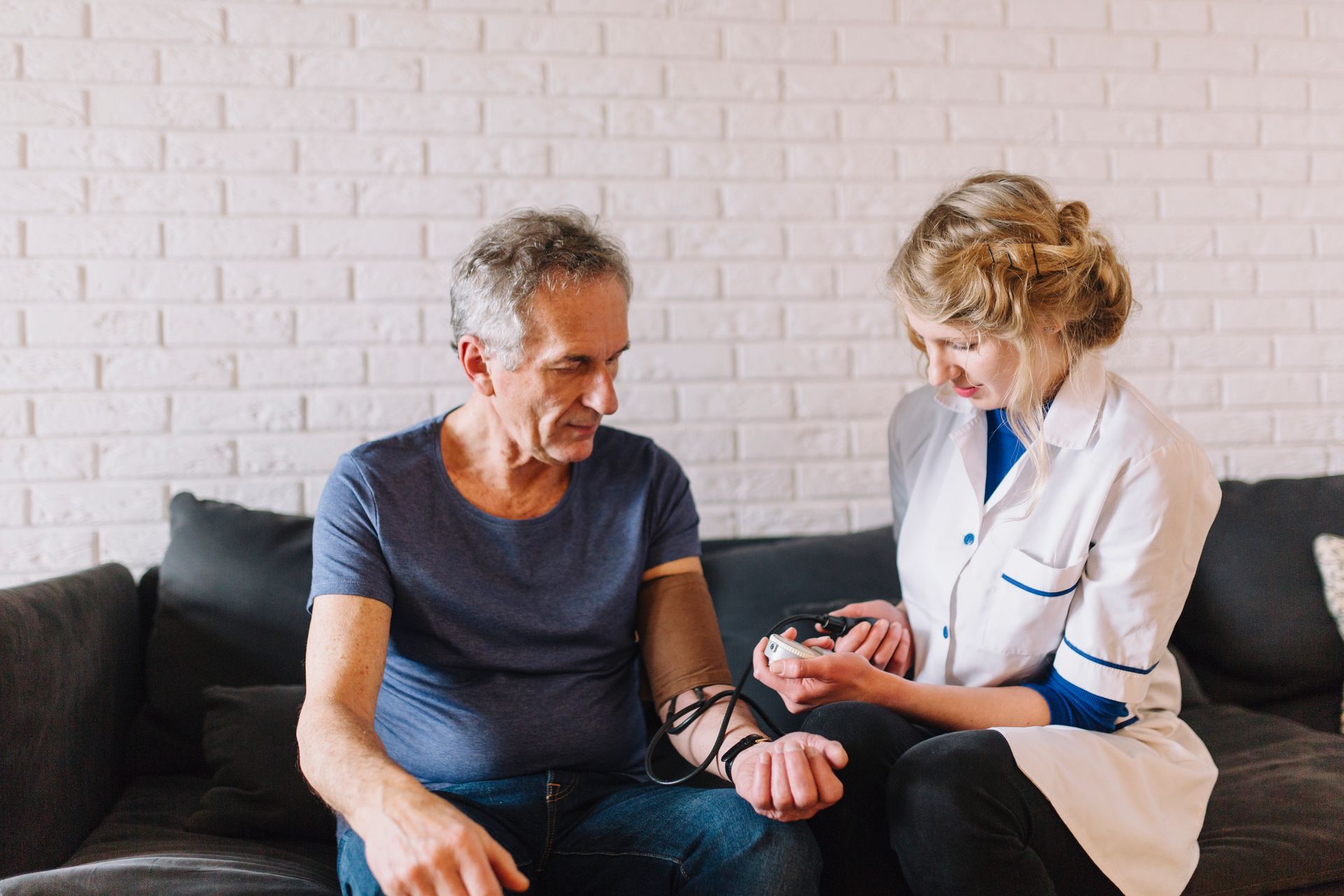 nurse checking blood pressure of elderly man