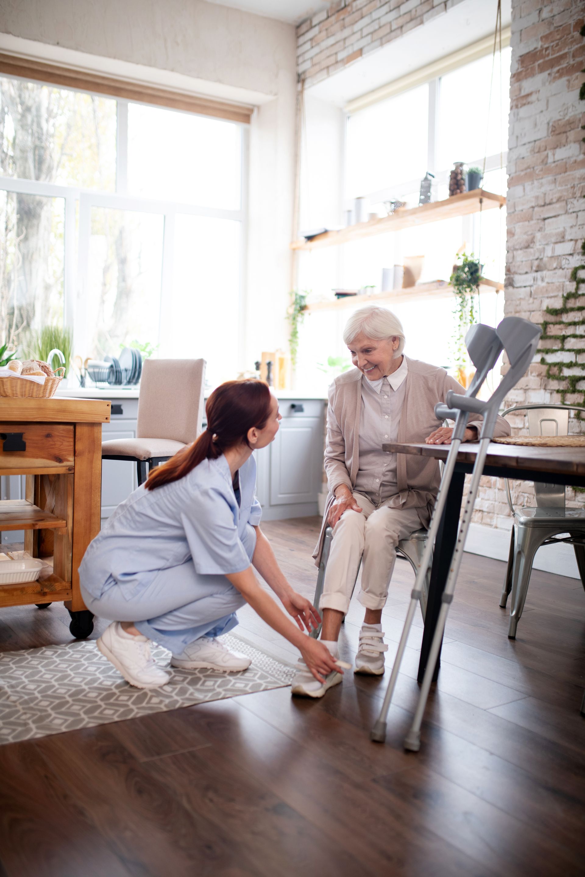 A nurse is helping an elderly woman with her walker.
