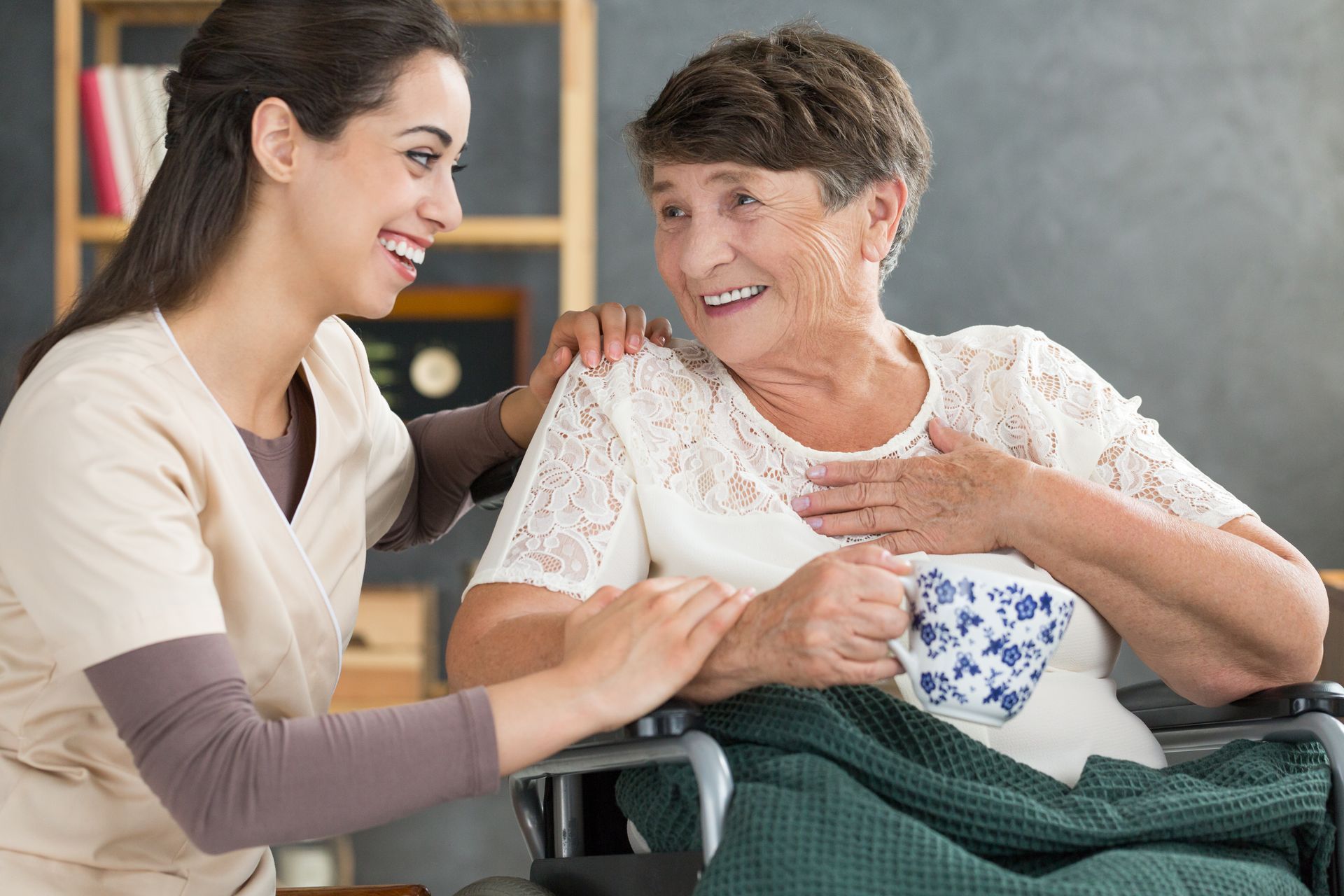 A nurse is talking to an elderly woman in a wheelchair.