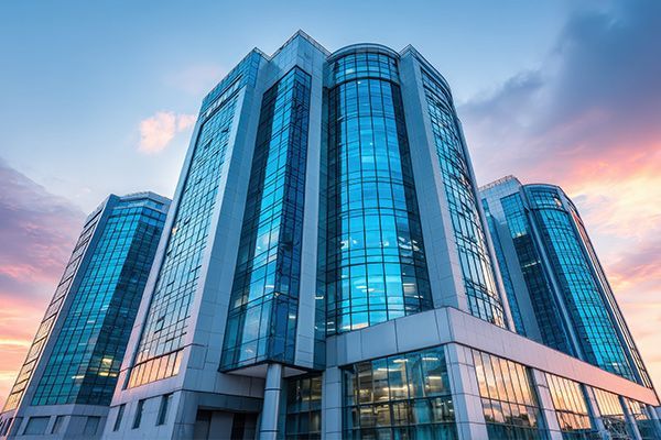 Glass office skyscraper with blue reflective windows against a clear sky