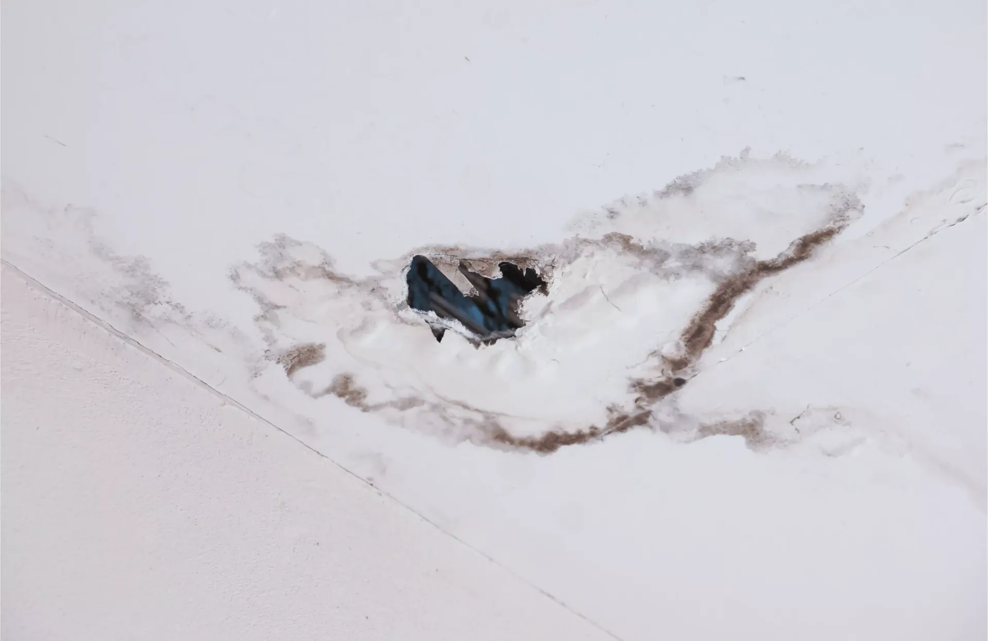 Close-up of a roof leak stain showing water damage around a roof penetration point in Havre de Grace, MD