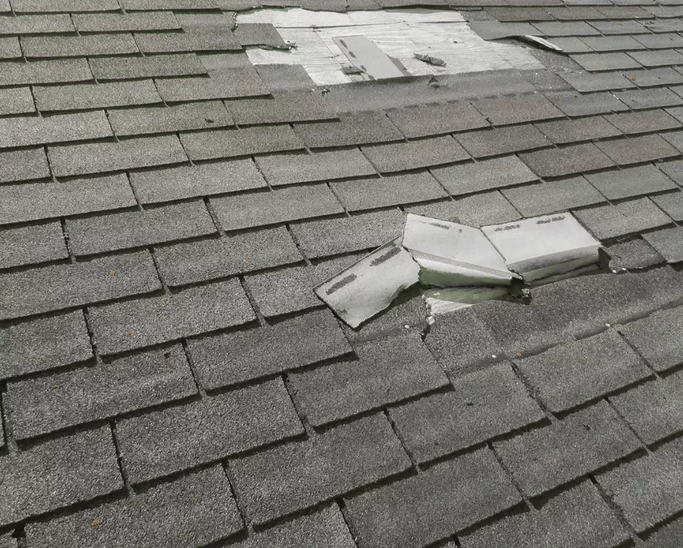 Blown-off shingles scattered on a Havre de Grace roof showing wind damage requiring patch repair