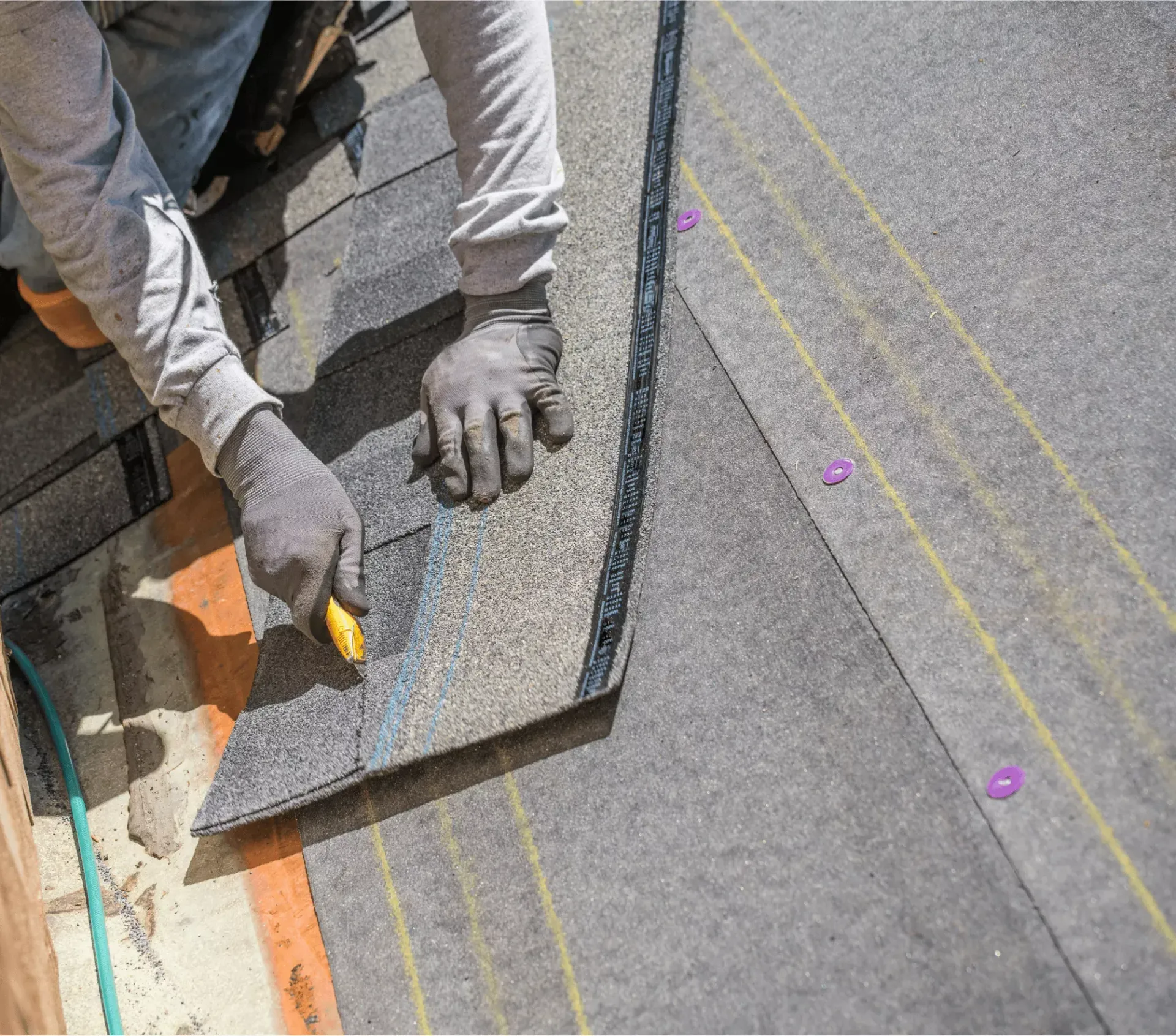 Roofer measuring and cutting underlayment during a roof replacement in Havre de Grace, MD