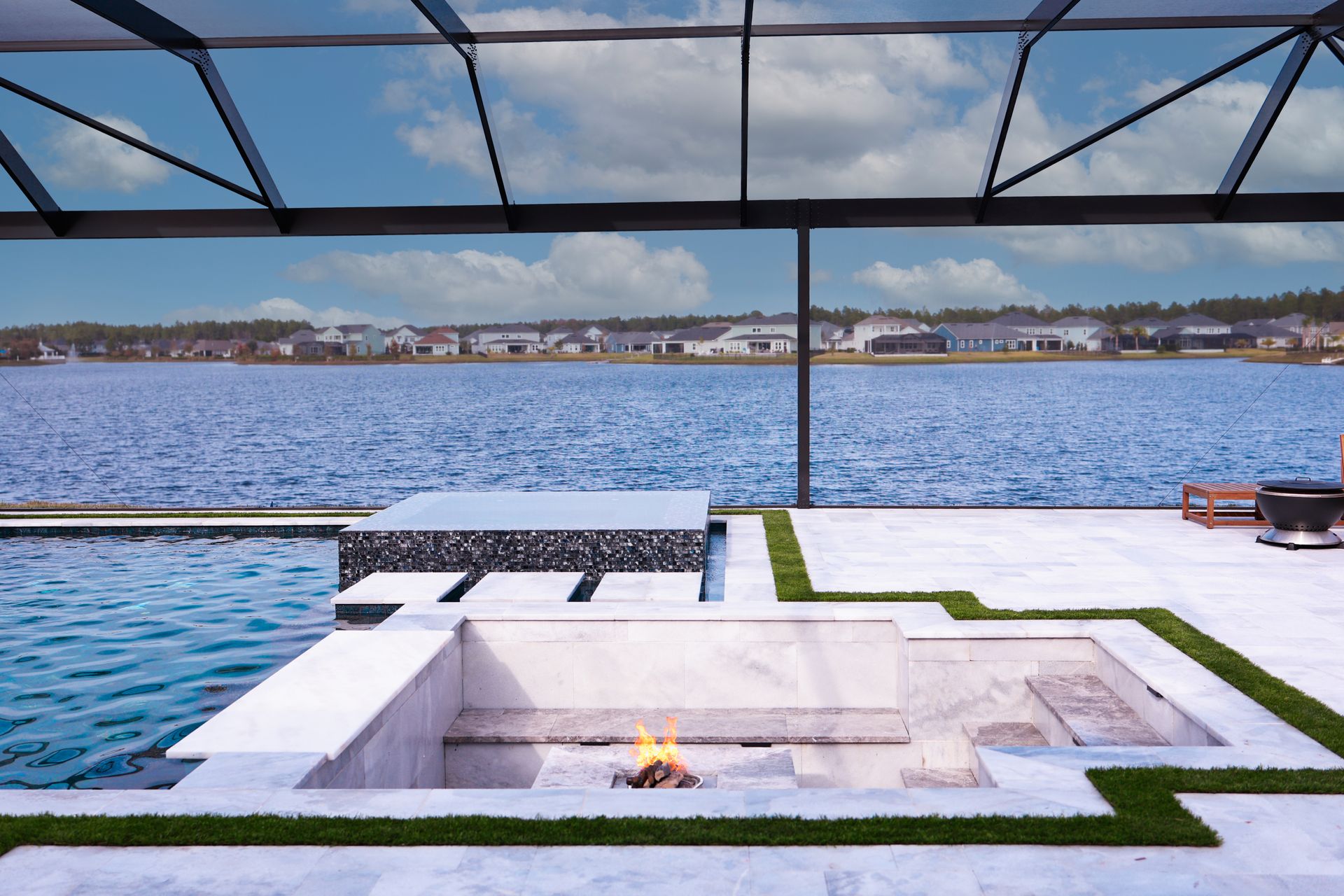 Modern house with pool, lawn, and sky; two-story, white with balcony.