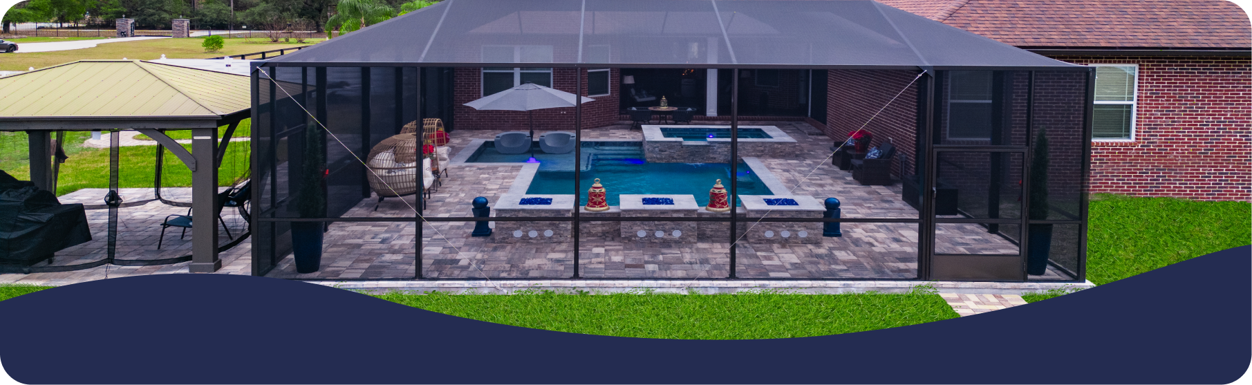 A backyard featuring a pool and hot tub inside a screened-in enclosure, with a separate gazebo on a patio nearby.
