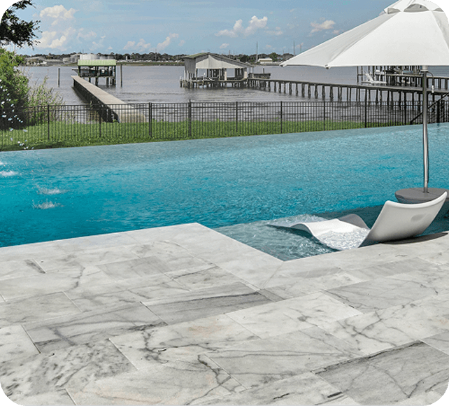 Modern pool with turquoise water, marble deck, and waterfront cabanas under a white canopy