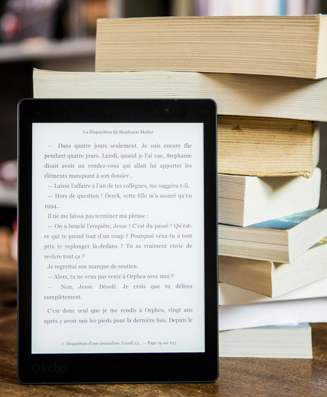 A tablet is sitting on top of a stack of books