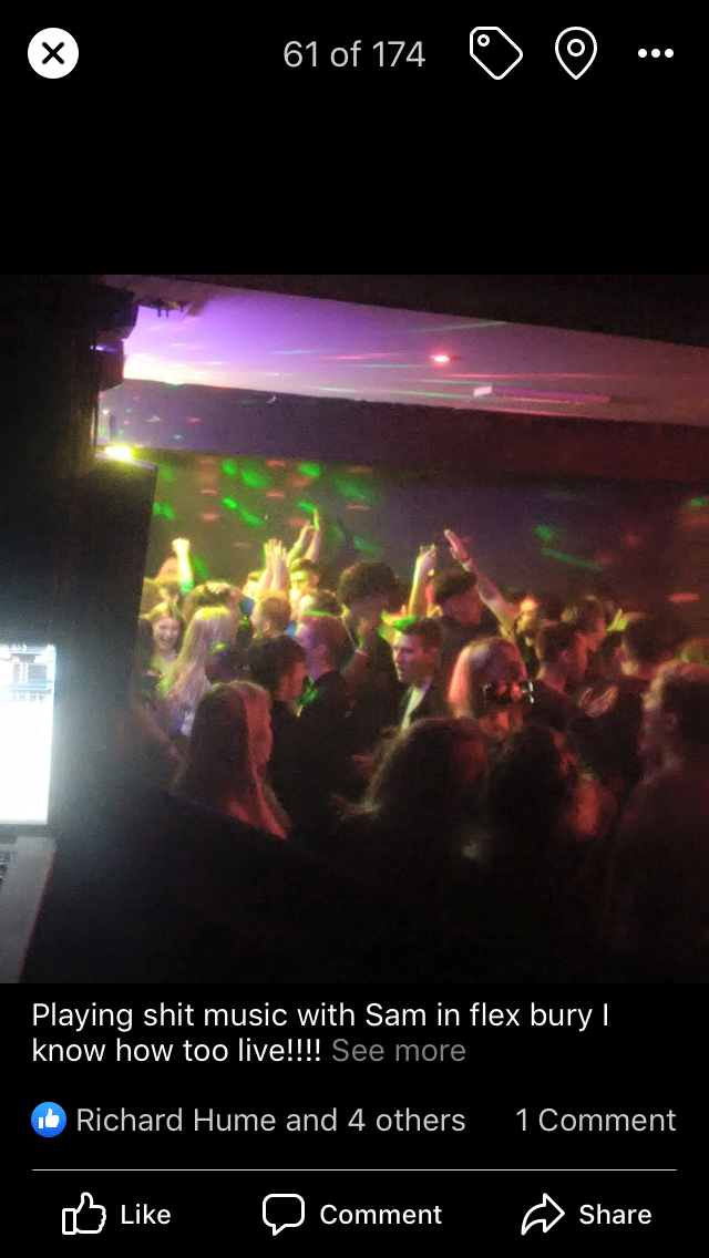 Many guests dancing in front of DJ in night club.