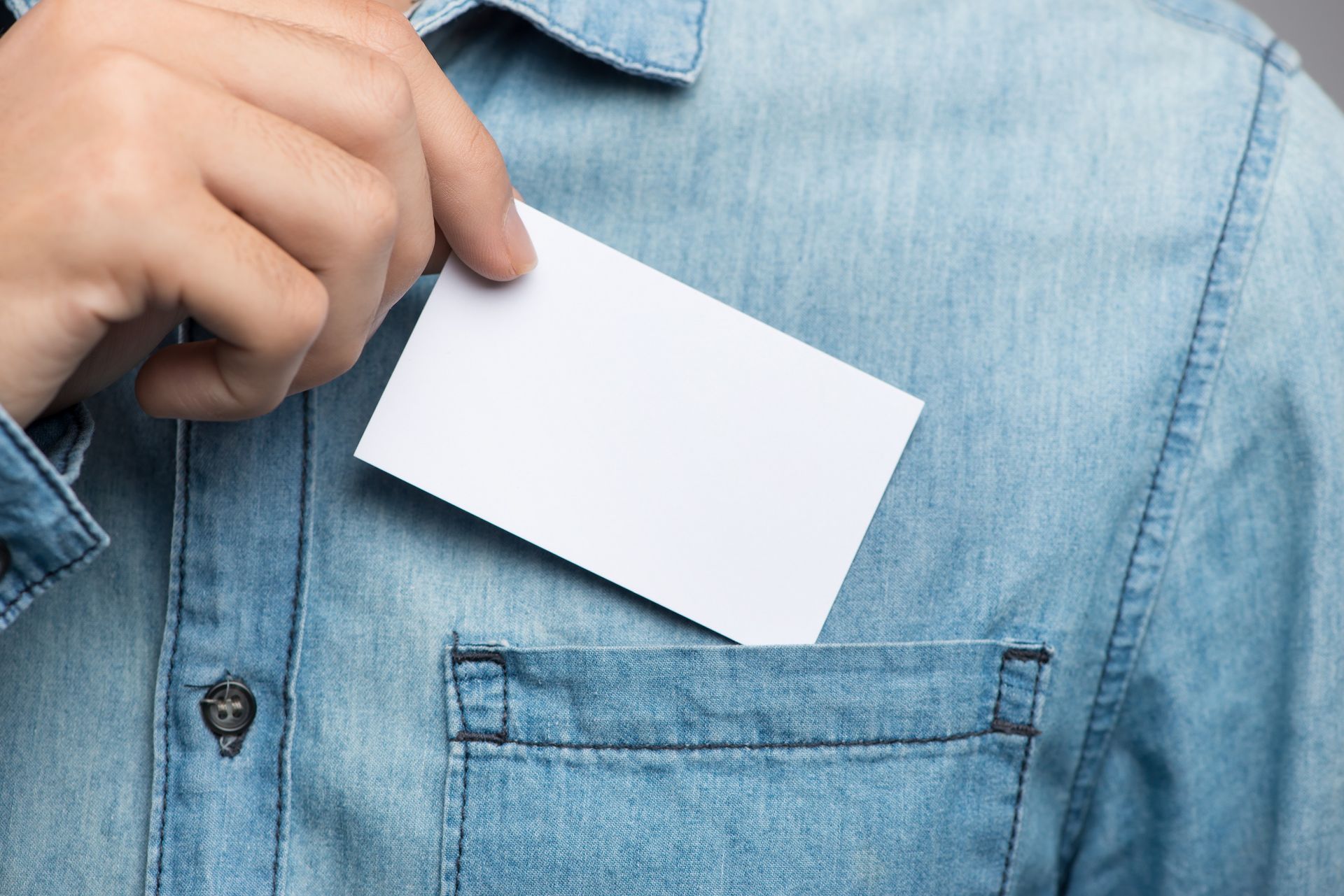 A person is pulling a business card out of their pocket