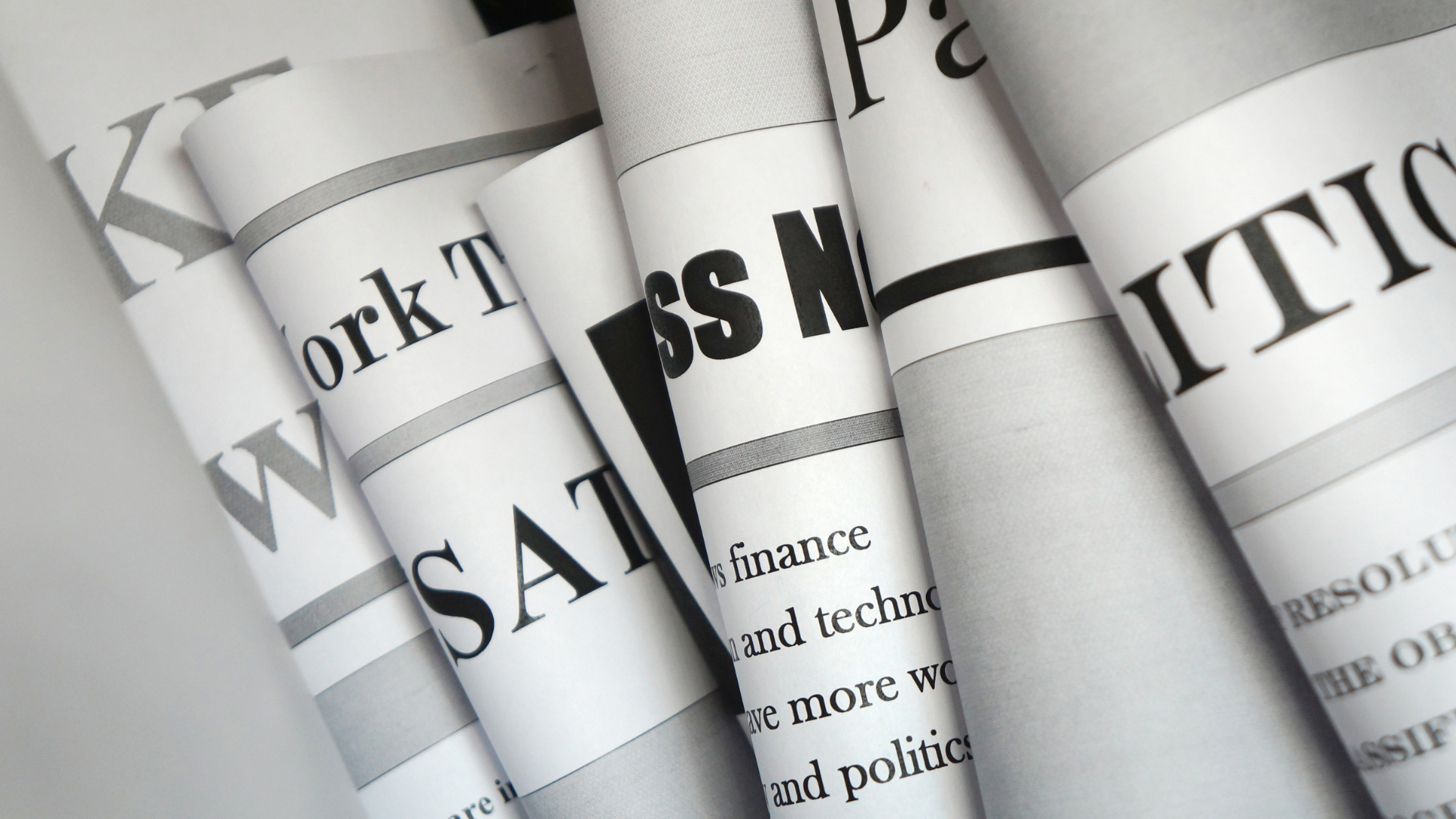 A bunch of newspapers are stacked on top of each other