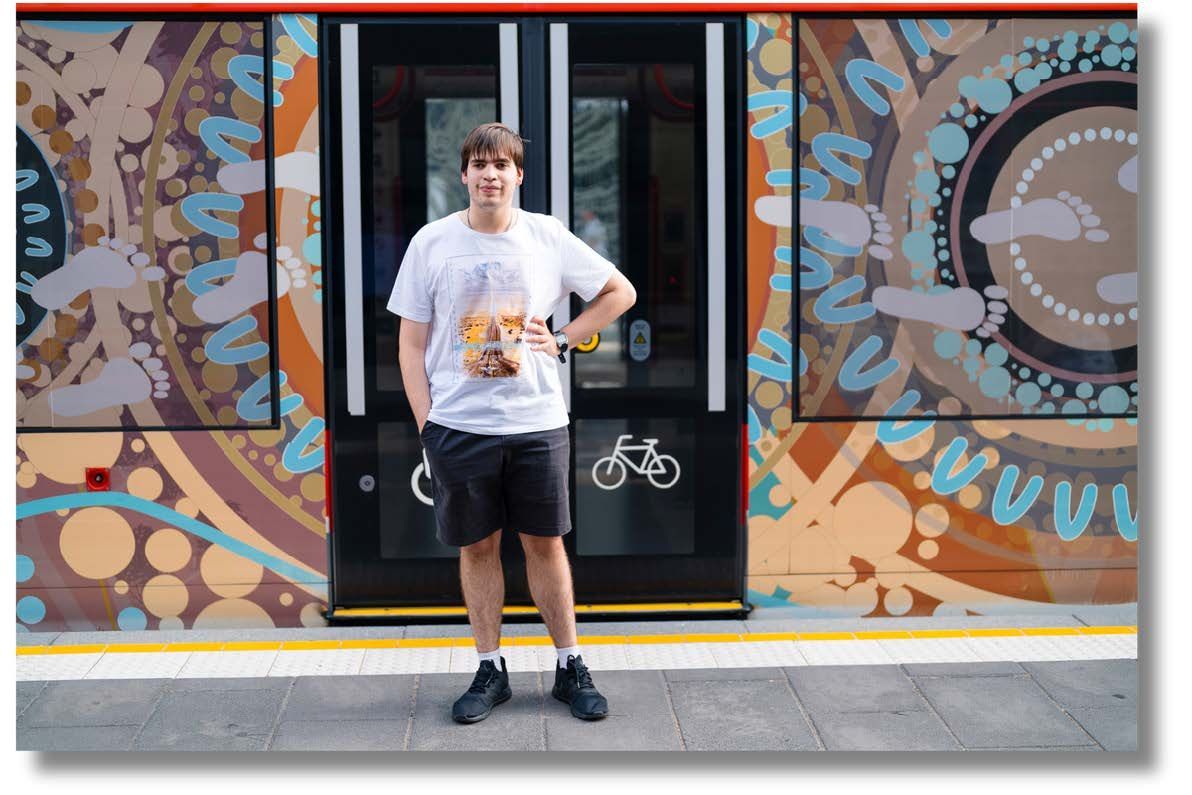 Image of an individual with their hand on their waist, in front of train doors, in Canberra.