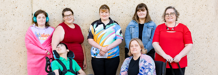 6 disabled women and 1 boy. 2 people are in wheelchairs and 1 has a support dog.