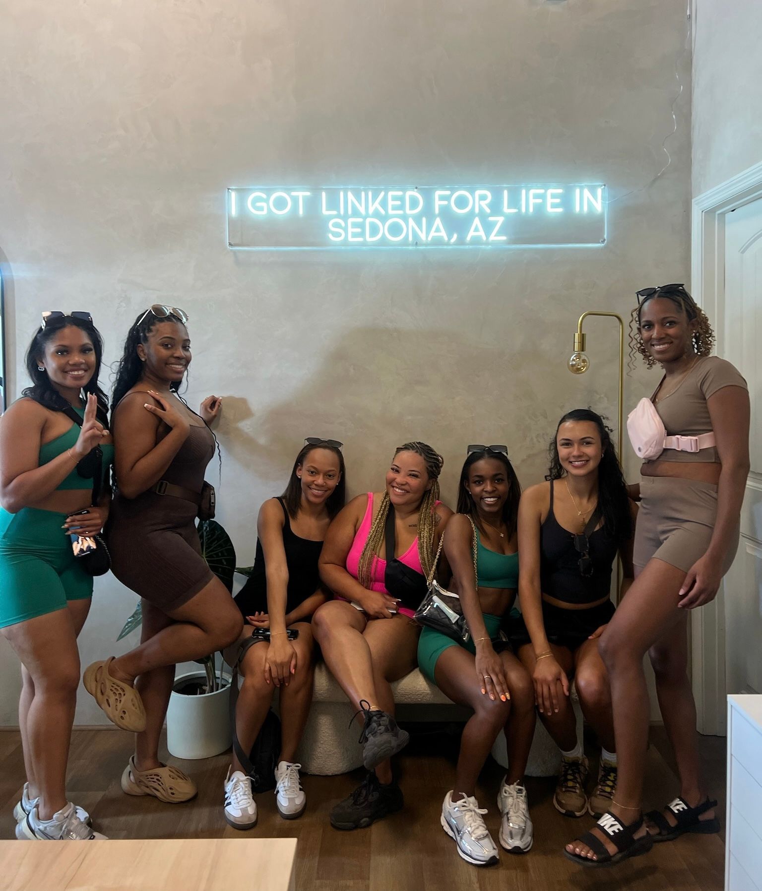 Six women posing indoors under neon text: “I GOT LINKED FOR LIFE IN SEDONA, AZ.”