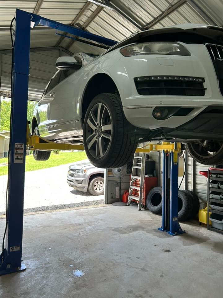 An Audi SUV raised on a car lift in a garage.