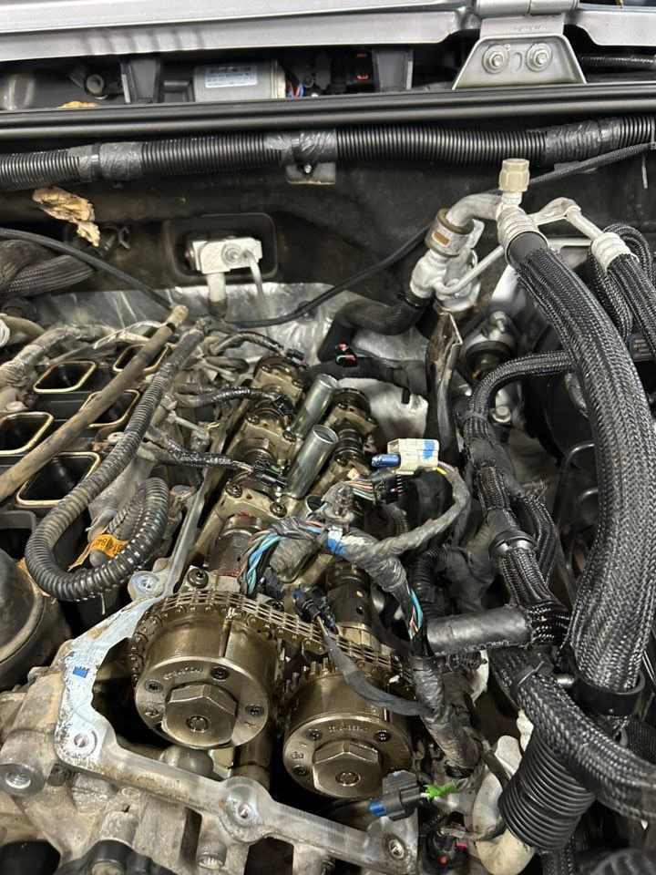 Open car engine, partially disassembled, with exposed components and wiring.
