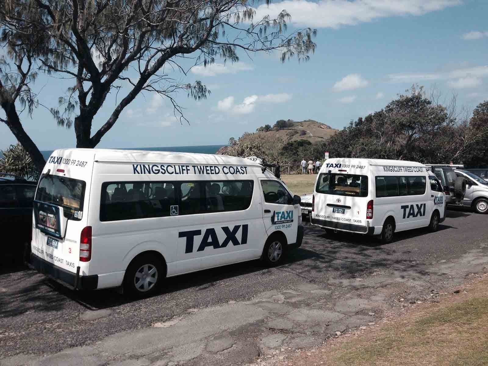 Two White Taxis Are Parked Next To Each Other On The Side Of The Road — Kingscliff Tweed Coast Taxis Pty Ltd In Tugun, QLD