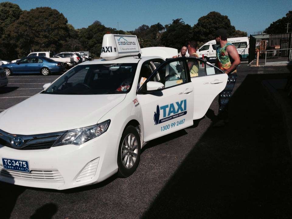 A White Taxi Is Parked In A Parking Lot — Kingscliff Tweed Coast Taxis Pty Ltd In Tugun, QLD
