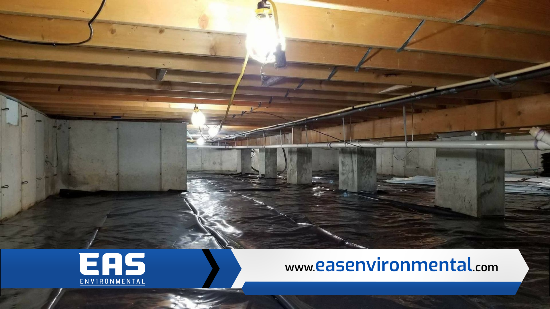 Crawl space with concrete supports, exposed beams, and a black vapor barrier.