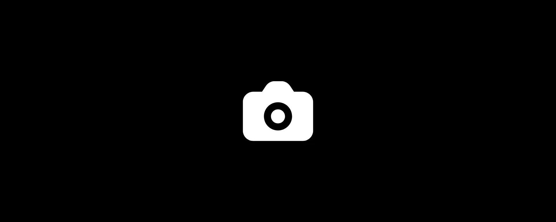 White camera icon on a black background.