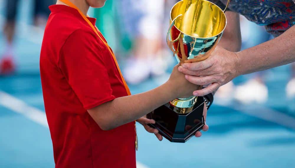 Man Giving A Trophy To A Child — NQ Plaques & Trophies In Kirwan, QLD