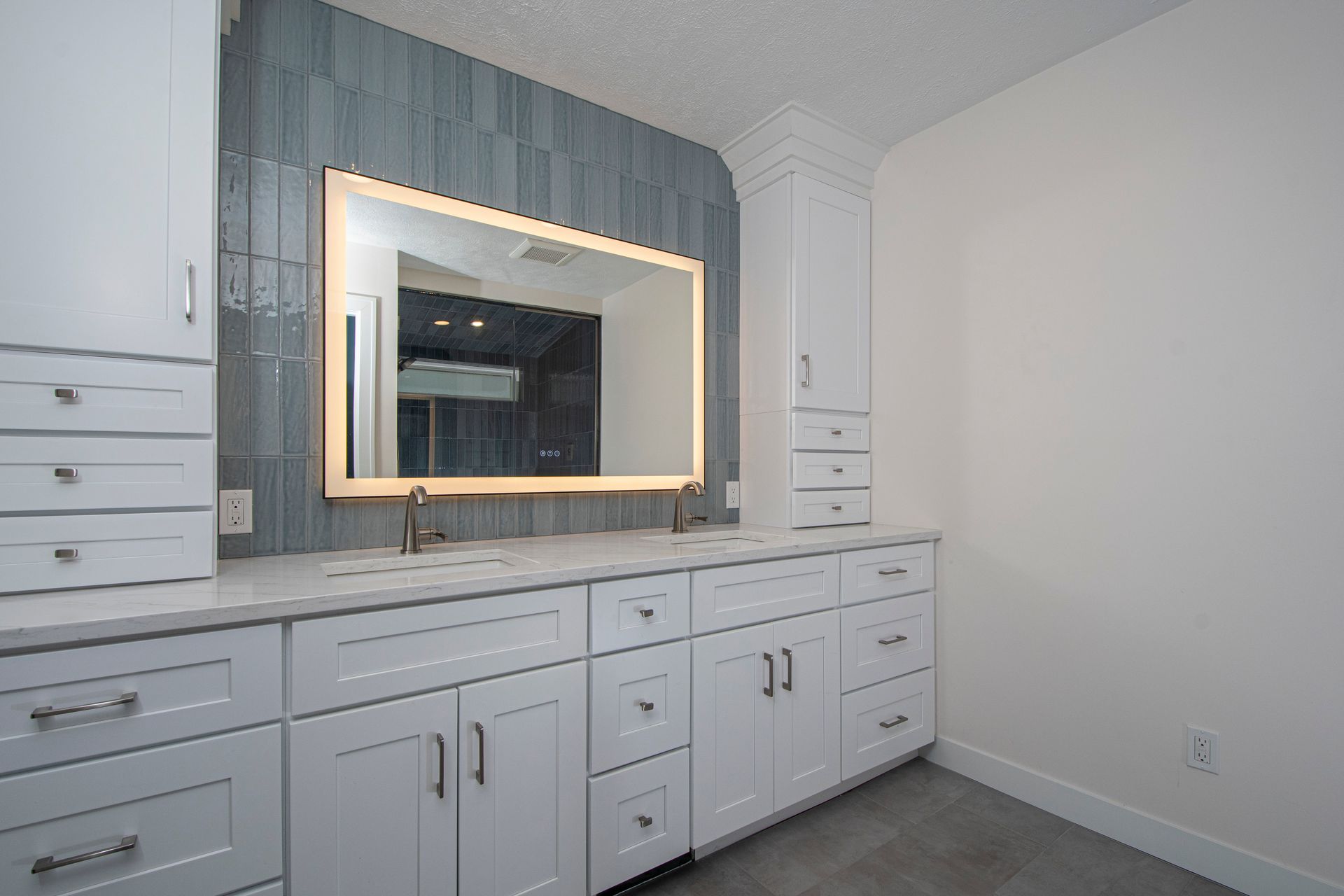 Modern white bathroom vanity with illuminated mirror and gray shiplap accent wall