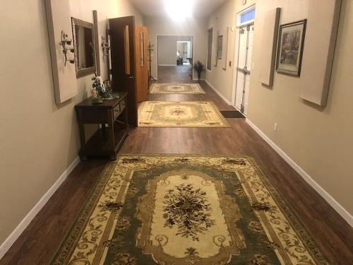 Long hallway with patterned rugs, framed art, and a wooden console table under warm lighting