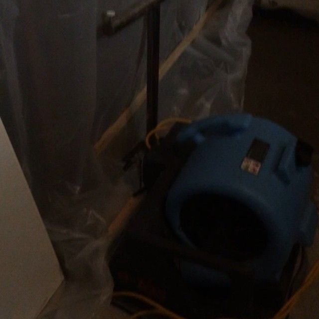 A blue vacuum cleaner is sitting in a dark room