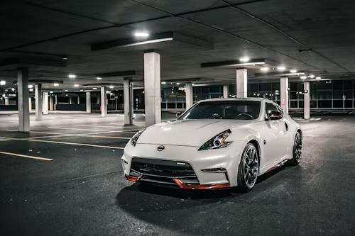 A white sports car is parked in a parking garage.