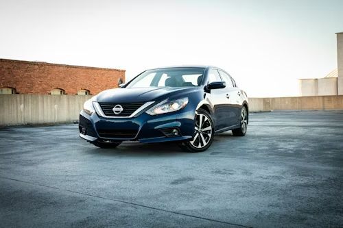 Blue Nissan Altima parked on a rooftop.