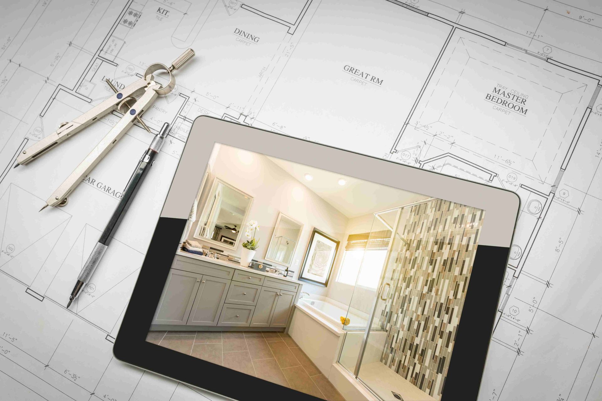 Designs for a bathroom remodel on an IPad and paper with protractor