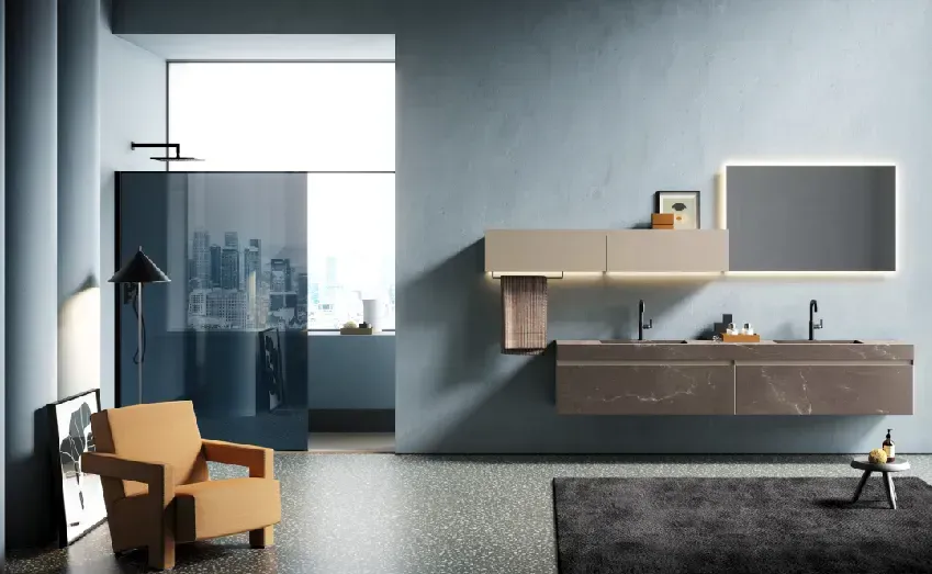 Bagno moderno con mobile lavabo sospeso, specchio retroilluminato e poltrona decorativa.