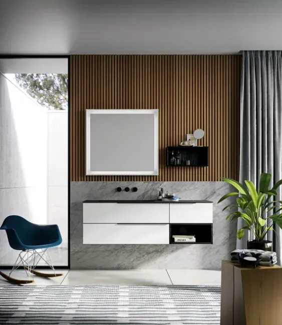 Bagno moderno con mobile lavabo sospeso, parete con pannelli in legno, specchio e sedia a dondolo.