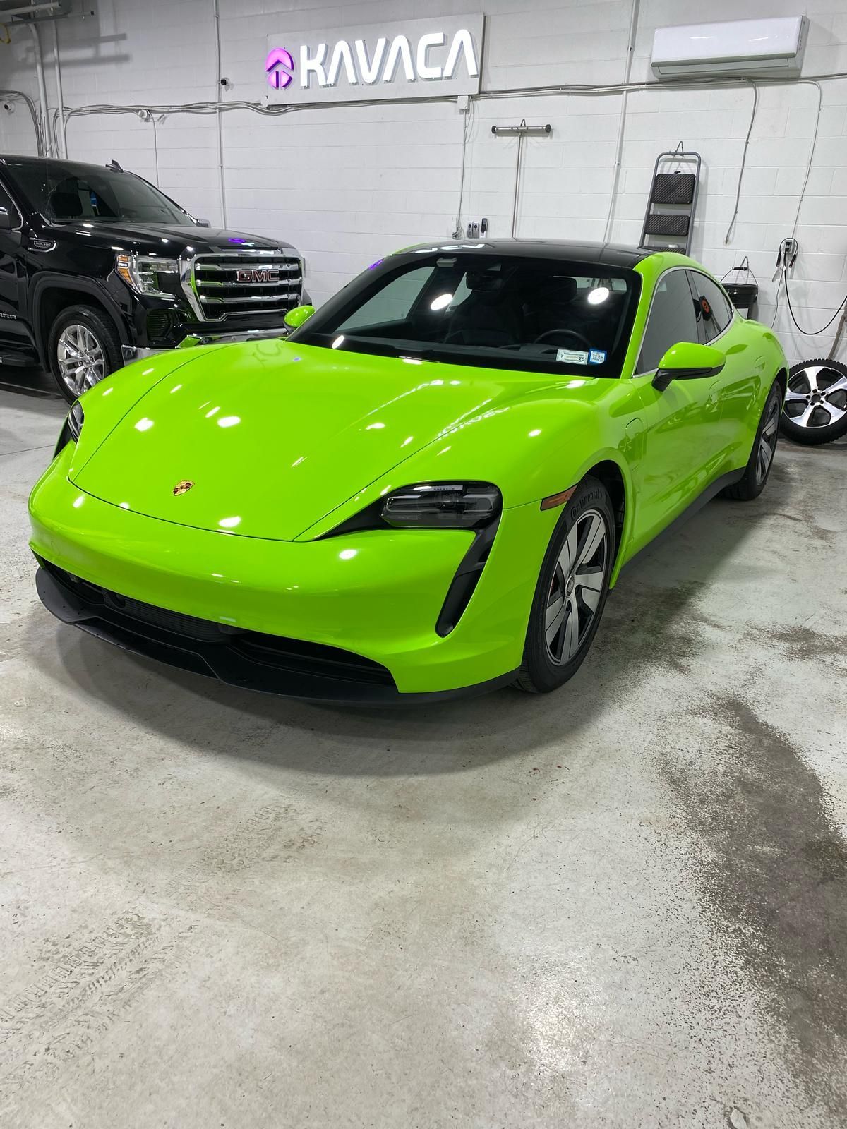 Bright lime green sports car parked indoors under a Kavaca sign.