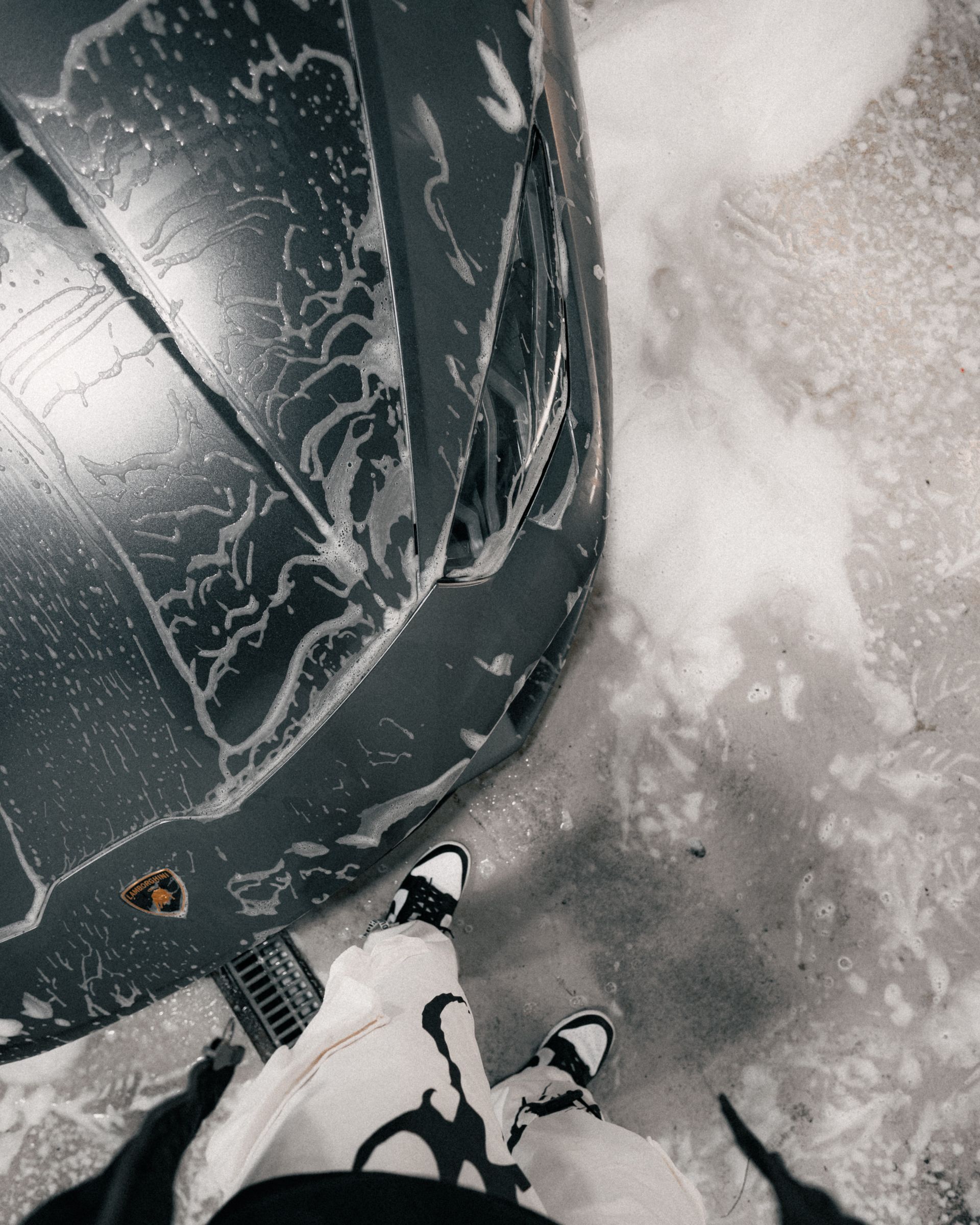 Snowmobile dashboard and rider’s boots on snowy ground, viewed from above