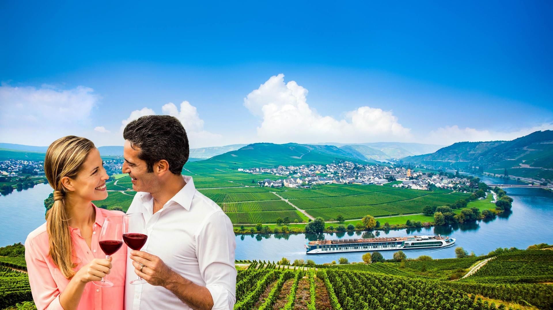 A man and a woman are holding glasses of wine in front of a vineyard.