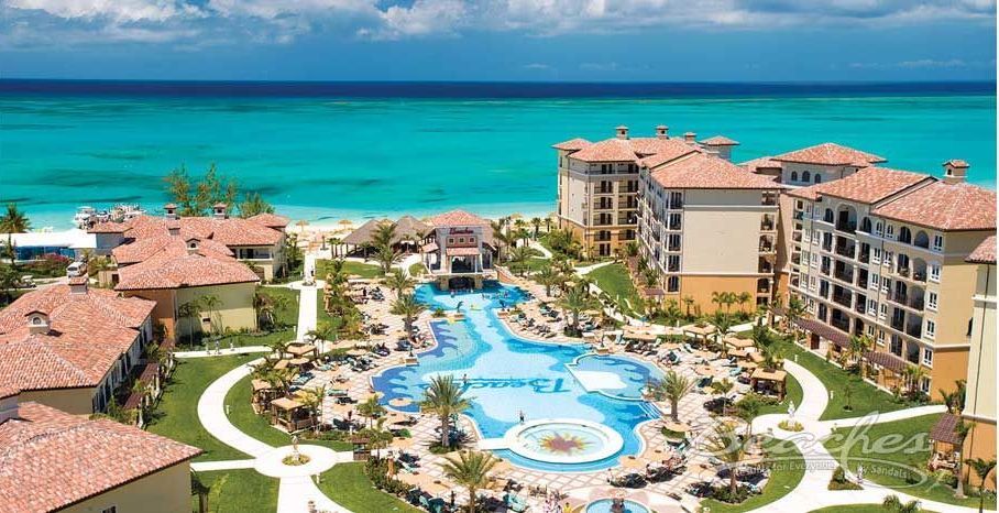 An aerial view of a resort with a large pool in the middle of it.
