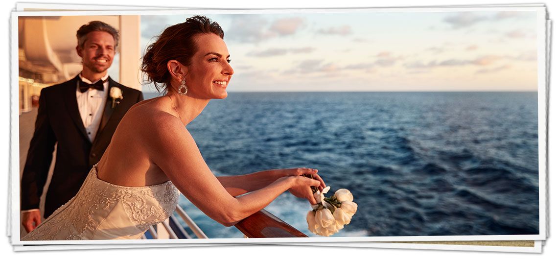 A bride and groom on a cruise ship looking out over the ocean.