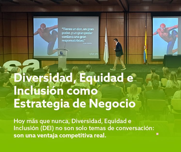 Conferencia sobre diversidad e inclusión en auditorio, con presentador y diapositivas en pantalla.