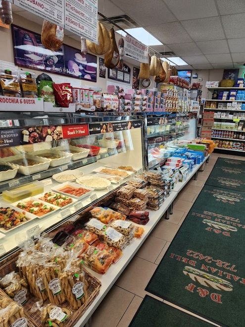 A grocery store filled with lots of food and a green rug.