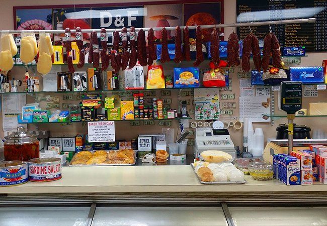 A counter in a grocery store with a lot of food on it.
