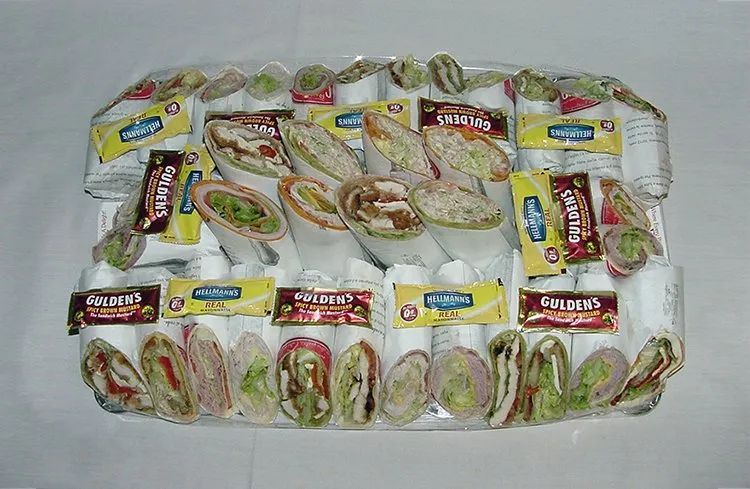 A tray of sandwiches and wraps on a table