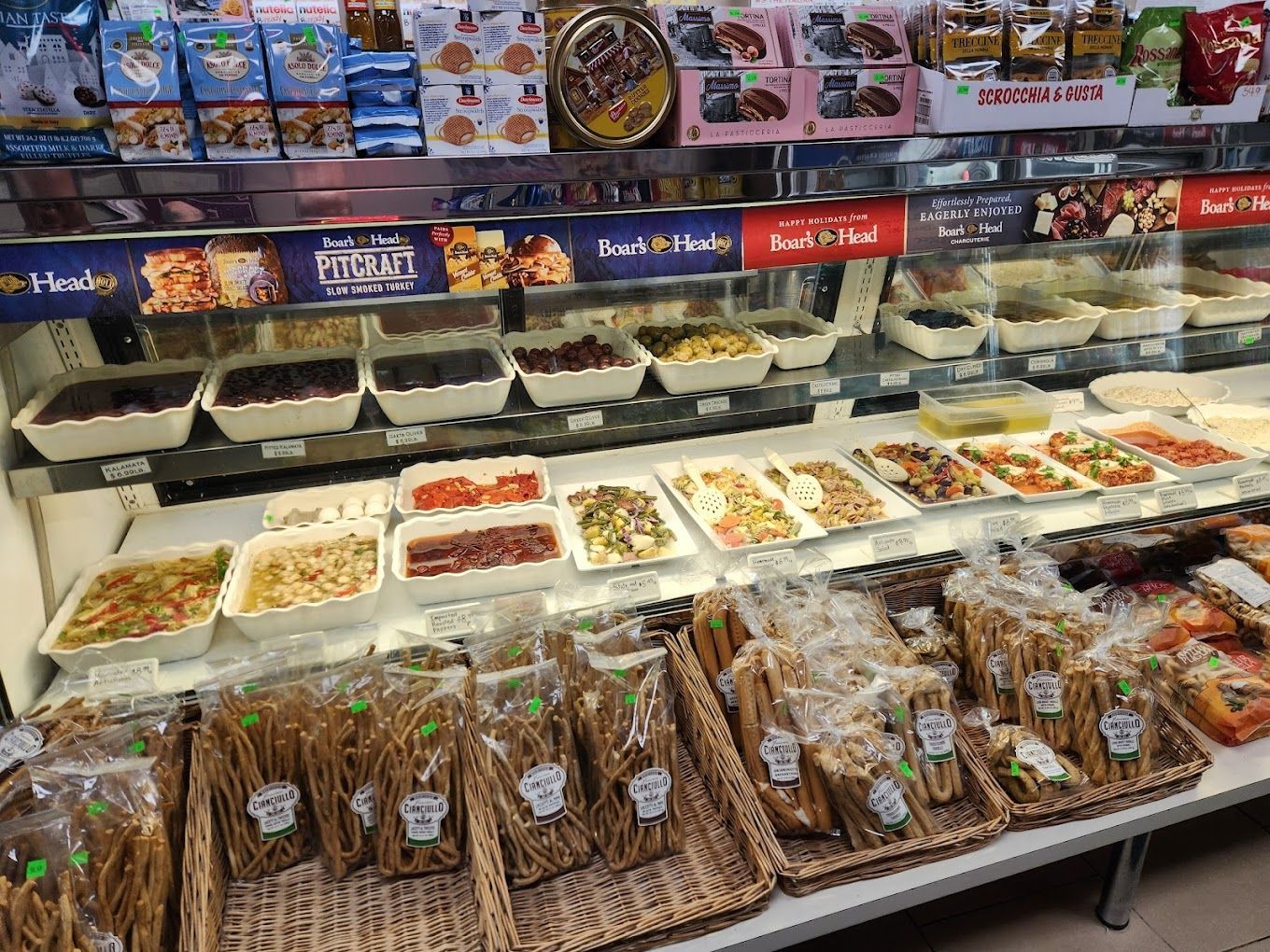 A display case filled with lots of food in a store.