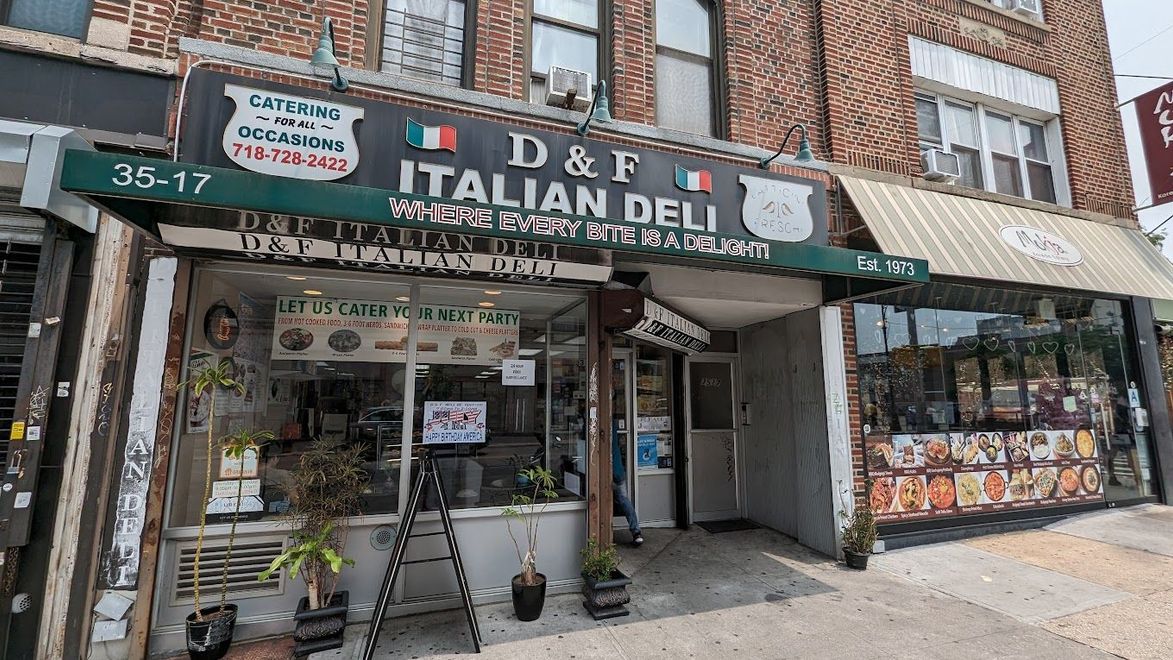 A brick building with a deli on the side of it.