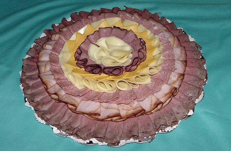 A tray of sliced meat and cheese on a table