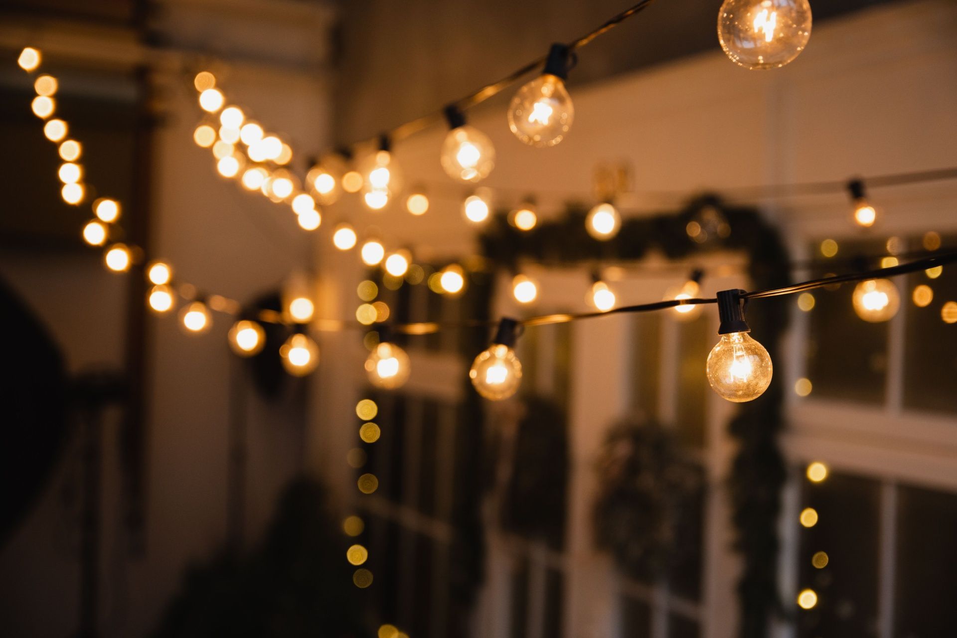 Warm string lights glowing against a blurred outdoor balcony at dusk